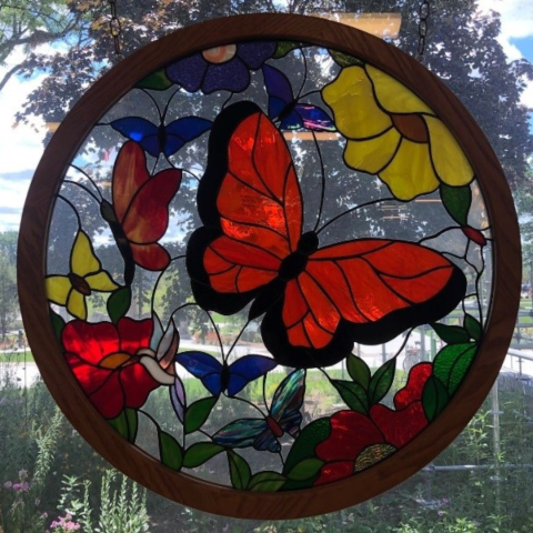 Stained glass butterfly and flowers on a window overlooking the butterfly garden