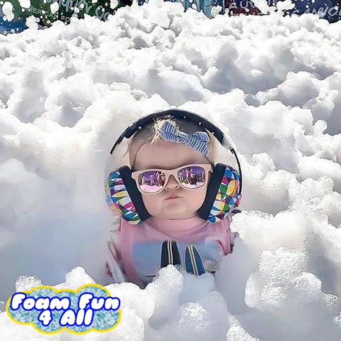 baby sitting in foam bubbles with headphones 