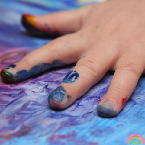 Toddler hand covered in paint, finger painting 