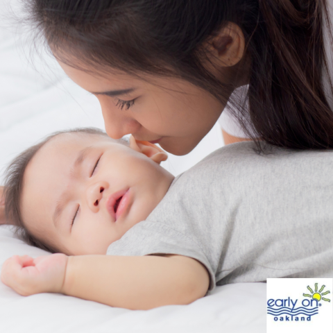 sleeping baby with parent giving kissses 