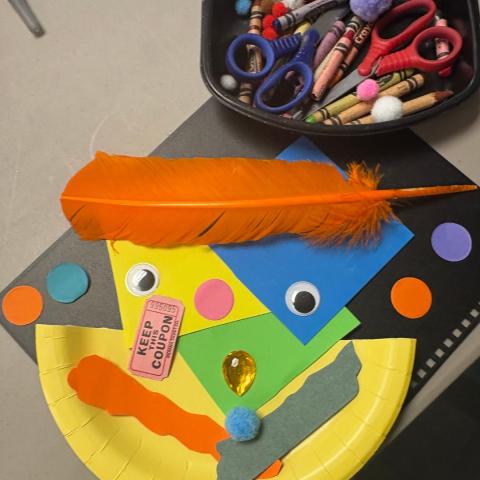 Multicolored plates, materials, crayons, feather, googly eyes to create artwork for this program.