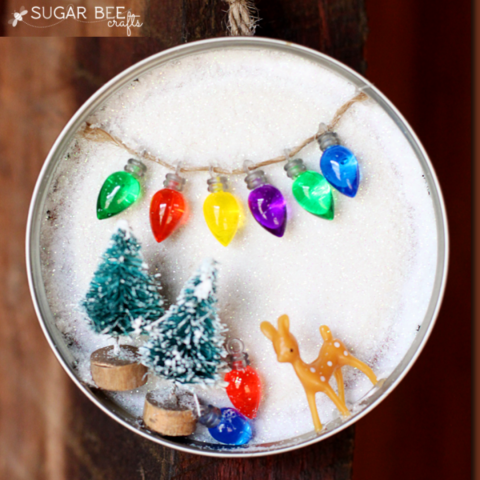 mason jar lid with fake snow and winter themed miniatures