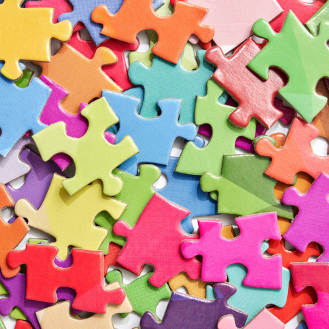 Puzzle pieces of multiple colors piled on each other