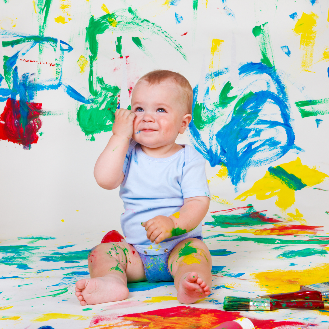 Baby Art Crawl. Baby covered in many colors of paint. 