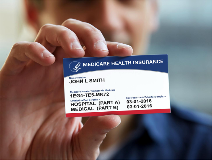 A person holding up a Medicare card in the foreground of the image.