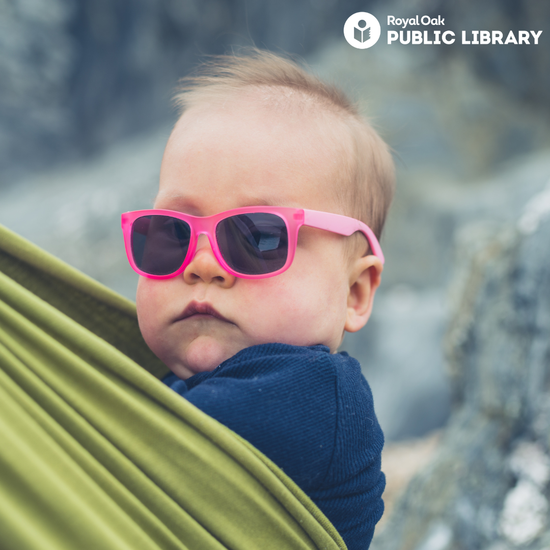 baby in carrier wearing pink sunglasses