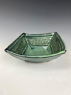 Green glazed clay candy dish with decorative designs. 