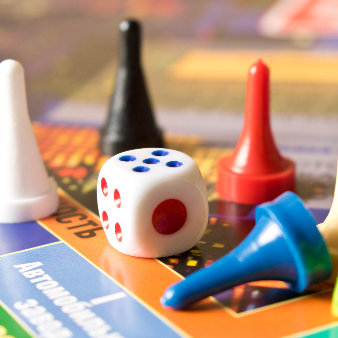 Colorful game pieces with dice on top of a game board. 