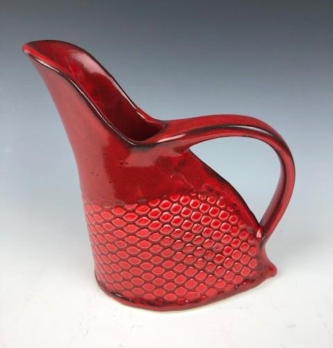 Handmade pitcher made of clay with a glaze color of bright red. 