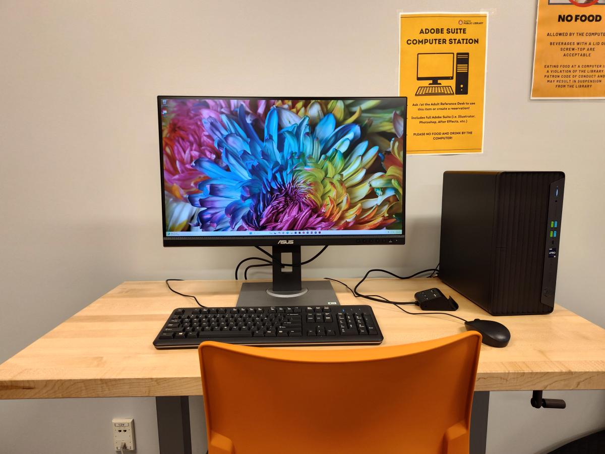 Computer workstation with chair and vibrant screen saver image.